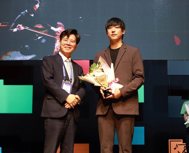 경기공연예술어워즈 시상식에서 김상회 경기아트센터 사장(왼쪽)과 대상 수상팀 마홀라 컴퍼니의 김재승 대표. 경기아트센터 제공