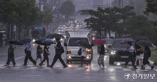 장마 영향으로 수도권 곳곳에 국지성 호우가 내리고 있는 6일 수원특례시 장안구 한 거리에서 시민들이 갑작스럽게 쏟아지는 장대비에 빠른 걸음을 재촉하고 있다. 홍기웅기자