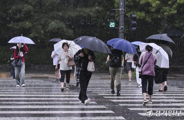 장마 영향으로 수도권 곳곳에 국지성 호우가 내리고 있는 6일 수원특례시 장안구 한 거리에서 시민들이 갑작스럽게 쏟아지는 장대비에 빠른 걸음을 재촉하고 있다. 홍기웅기자