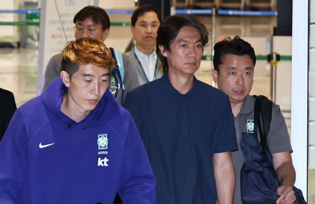 2026 북중미 월드컵에서 사상 최악의 성적을 낸 홍명보 전 축구대표팀 감독(가운데)이 지난 6월 30일 인천국제공항 제2여객터미널을 통해 귀국하고 있다. 연합뉴스