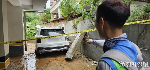 9일 평택시 팽성읍 부용로55번길 인근 A빌라에서 옹벽이 무너지며 주차된 SUV 차량을 덮친 가운데 차주 B씨가 파손된 차량을 가리키고 있다. 윤동현기자