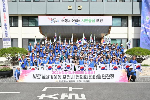 백영현 포천시장과 정미옥 바르게살기운동 포천시협의회장이 10일 ‘2026년 한마음 연찬회’를 마친 뒤 회원들과 포천시청 본관 앞에서 태극기를 들고 기념촬영을 하고 있다. 포천시 제공