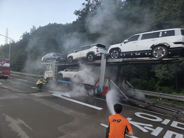 12일 오전 충남 통영대전고속대로에서 탁송차에 불이 나 인천소방대원들이 불을 끄고 있다. 인천소방본부제공