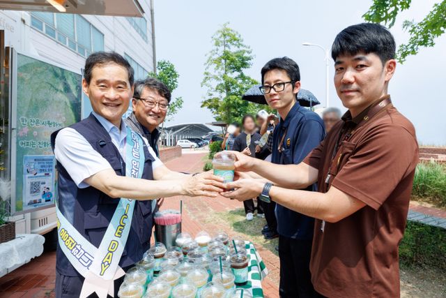 김범호 인천국제공항공사 사장 직무대행(왼쪽)이 지난 4일 인천공항 안 물류단지에서 근로자들에게 시원한 음료를 건네고 있다. 공항공사 제공
