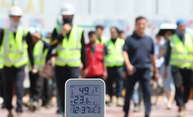 서울 전역에 '폭염중대경보'가 발효된 5일 서울 강남구 한 공사현장 부근 횡단보도에서 공사 관계자들이 이동하고 있다. 연합뉴스 제공