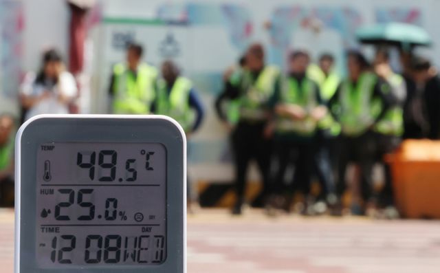 서울 전역에 '폭염중대경보'가 발효된 지난 5일 서울 강남구 한 공사현장 부근 횡단보도에서 공사 관계자들이 이동하고 있다. 연합뉴스