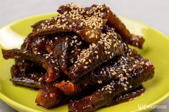 양념에 버무린 개소겡 무침 위에 깨를 뿌려 담은 접시에 담았다. / 위키푸디