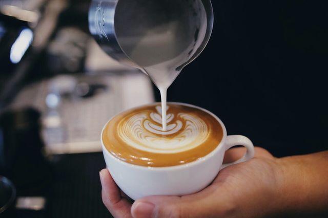 커피에 우유를 붓는 바리스타 손의 모습이다. /Mallika Home Studio-shutterstock.com