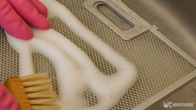 후드 필터 위에 낸 세제 거품을 솔로 문지르는 모습이다. / 위키푸디