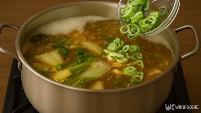끓는 얼갈이배추 된장국에 대파를 넣어 마무리하는 과정이다. / 위키푸디