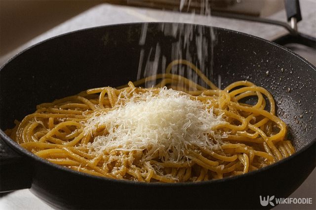 파스타에 치즈를 뿌리고 있다. / 위키푸디