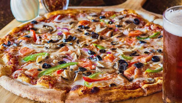 올리브가 토핑으로 올라간 피자가 놓여 있다. / JamesStefiuk-shutterstock.com