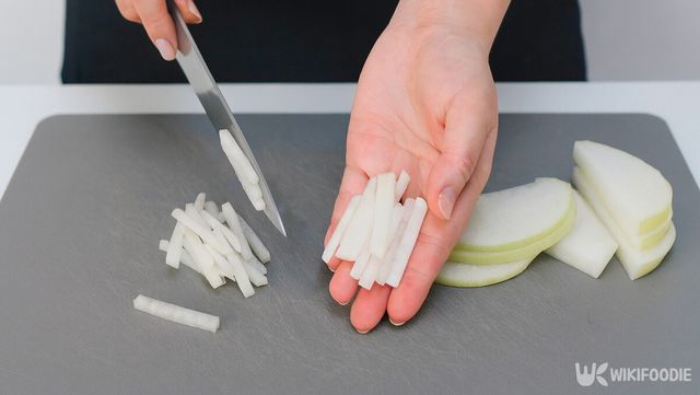 썰어둔 무를 한입 크기의 채로 다듬고 있다. / 위키푸디
