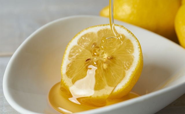 레몬이 담긴 접시에 꿀을 넣고 있다. / manbo-photo-shutterstock.com