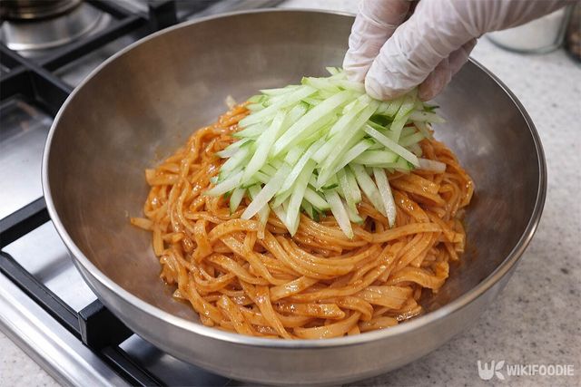 채를 썬 오이를 고명으로 얹고 있다. / 위키푸디