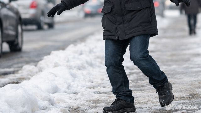 눈이 얼어붙은 인도 위에서 중심을 잡으며 조심스럽게 발걸음을 옮기는 보행자의 하반신 모습이다. / 위키푸디