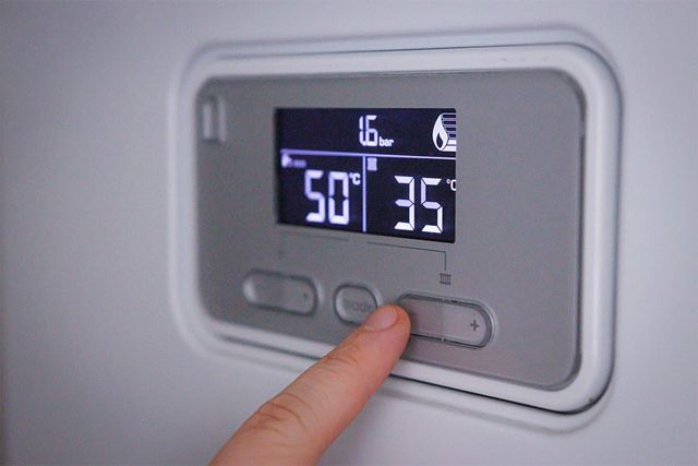 보일러 버튼을 누르고 있다. / Martin Gregor-shutterstock.com