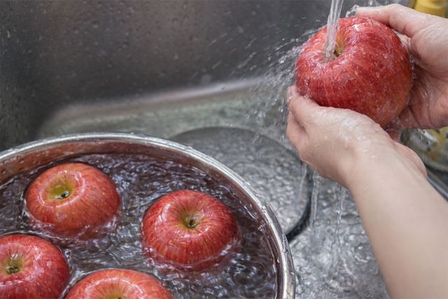 베이킹소다로 문지른 사과를 흐르는 물에 씻고 있다. / 위키푸디