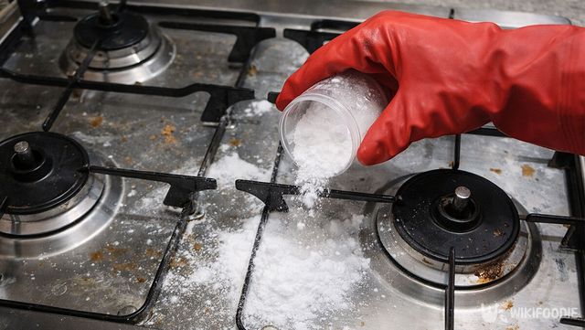 더럽혀진 가스레인지에 베이킹소다를 붓고 있다. / 위키푸디
