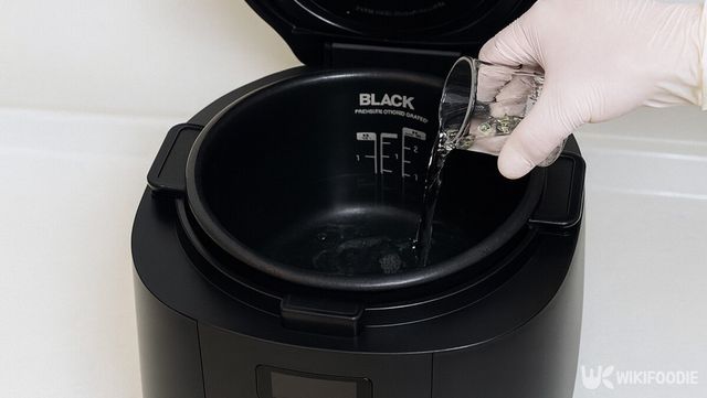 밥솥 속으로 계량컵의 물을 붓는 장면이다. / 위키푸디