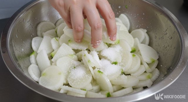 얇게 썬 무에 천일염과 설탕을 섞고 있다. / 위키푸디
