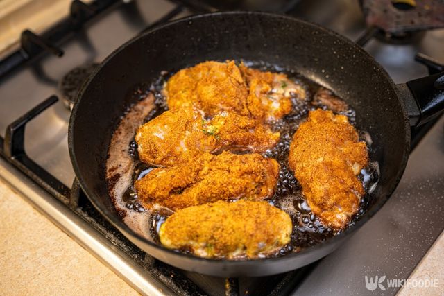 식용유를 뿌린 프라이팬 위에서 치킨을 굽는 모습. / Ezume Images-shutterstock.com