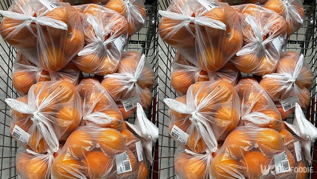 오렌지가 가득 담긴 봉지를 카트에 싣는 모습. / Mike Loik-shutterstock.com