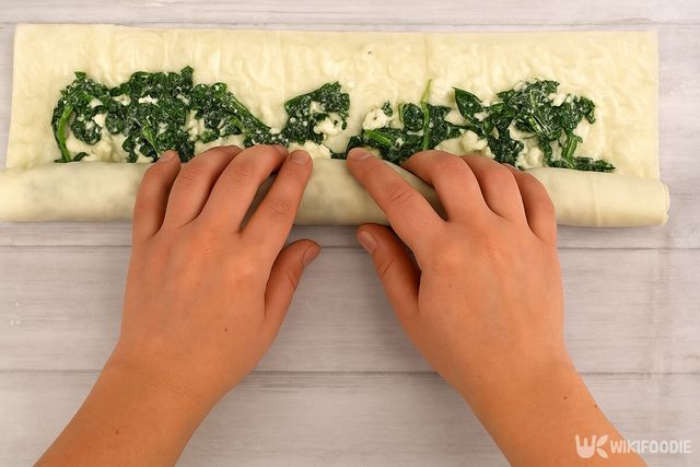 필로 반죽 위에 재료를 넣고 돌돌 말아주는 모습. / 위키푸디