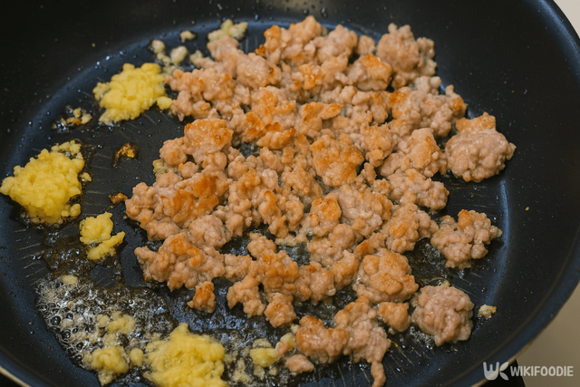 팬에 기름을 두르고 다진 마늘과 다진 고기를 볶는 자료 사진. / 위키푸디