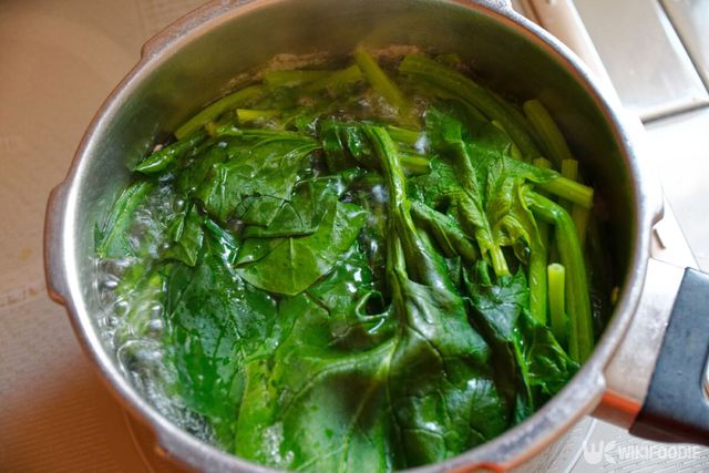 부엌에서 시금치를 끓이는 모습. / makieni-shutterstock.com