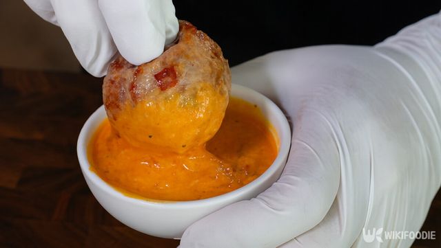 주먹밥 튀김을 소스에 찍는 자료 사진. / 위키푸디