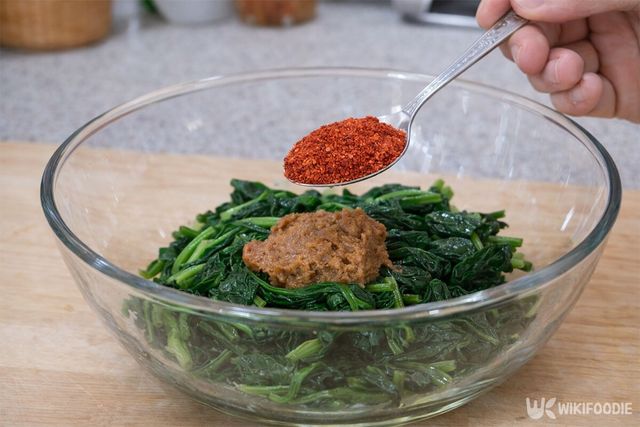 데친 시금치에 된장과 고춧가루를 넣고 있다. / 위키푸디