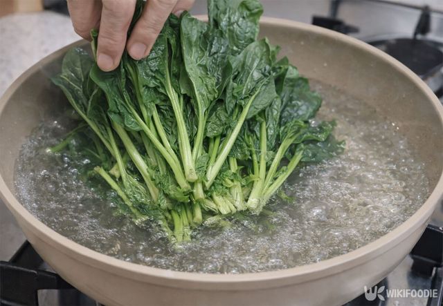 시금치를 끓는 물에 넣고 있다. / 위키푸디
