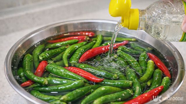 고추가 담긴 대야에 식초를 부어 농약을 제거하고 있다. / 위키푸디