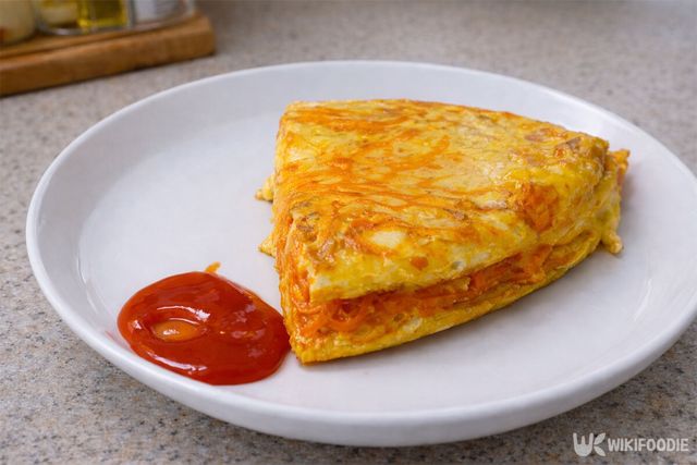 완성된 당근 달걀전과 스리라차 소스가 접시에 담겨 있다. / 위키푸디