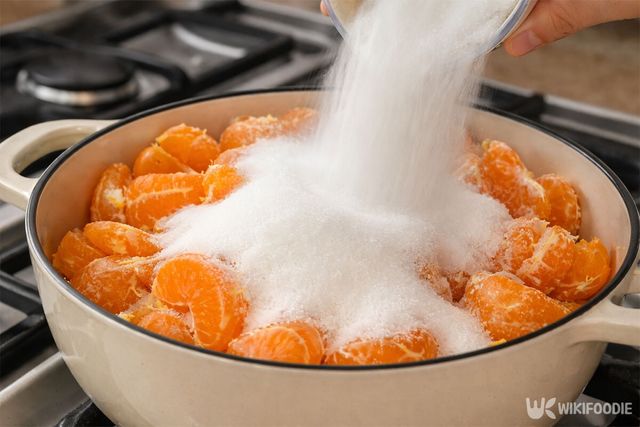 냄비에 귤을 넣고 설탕을 붓고 있다. / 위키푸디