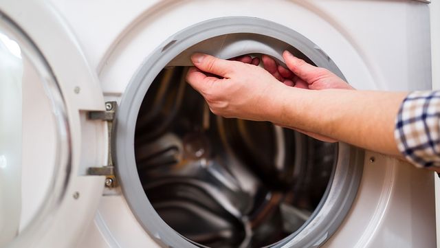 드럼세탁기 문 고무 패킹을 손으로 벌려 내부를 확인하고 있다. / adriaticfoto-shutterstock.com