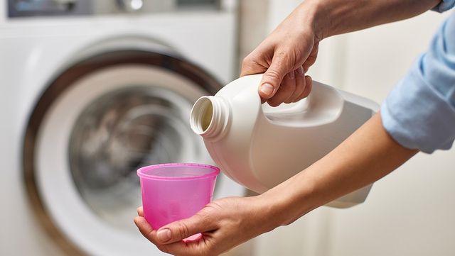 세탁기 청소를 위해 액체 세제를 계량컵에 따르고 있다. / Evgenyrychko-shutterstock.com