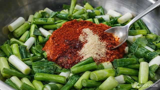 스테인리스 볼에 큼직하게 썬 대파가 담겨 있고, 가운데에는 고춧가루와 고운 양념 가루가 산처럼 올려져 있다. / 위키푸디