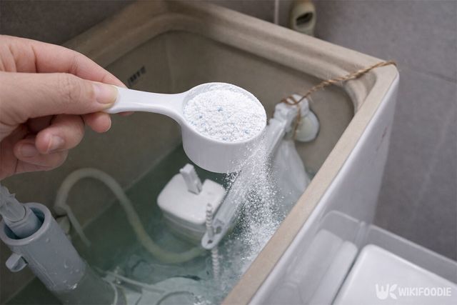 변기 물통에 베이킹소다 한 스푼을 들고 있다. / 위키푸디
