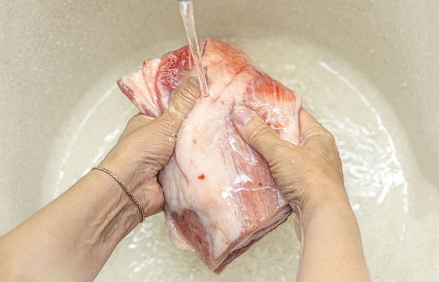 싱크대에서 날고기를 세척하고 있다. / Kornienko Alexandr-shutterstock.com