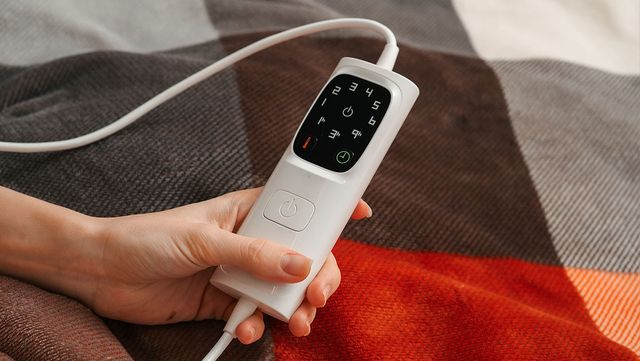 전자 매트 리모컨 버튼을 누르고 있다. / Bohdan Aleksandrovych-shutterstock.com