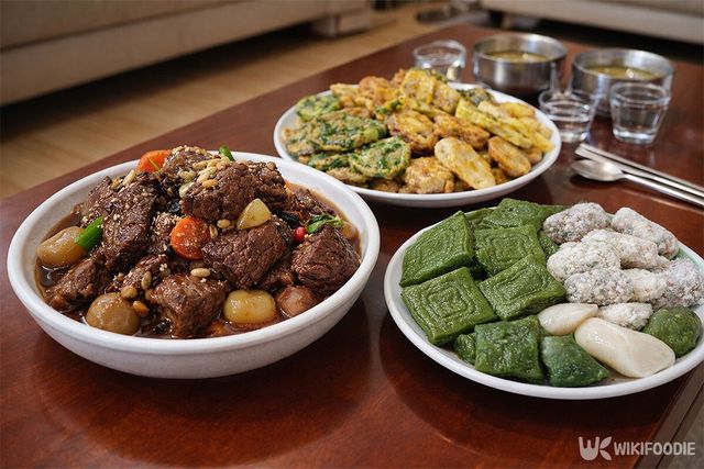 식탁에 갈비찜, 전, 쑥떡이 나란히 놓여 있다. / 위키푸디