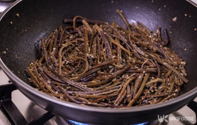 센 불에서 빠르게 볶아 겉면을 코팅한 고사리. 들기름과 양념이 고루 배어 윤기가 돈다. / 위키푸디