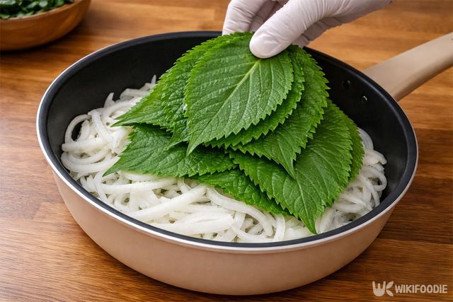 채 썬 양파에 깻잎을 올리고 있다. / 위키푸디