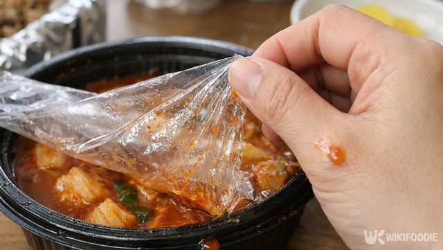 한쪽만 뜯긴 비닐이 안쪽으로 말리며 소스가 손에 묻는 모습이다. / 위키푸디