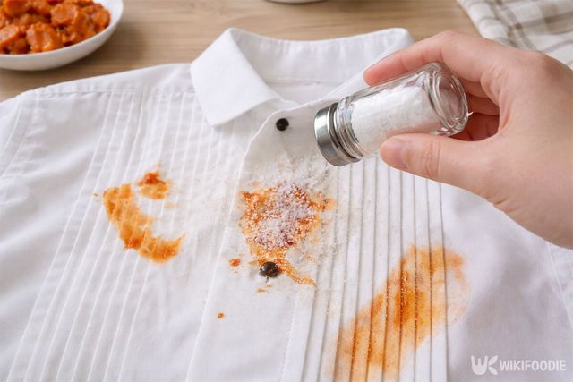 김칫국물이 묻은 흰 셔츠에 통에 든 소금을 뿌리는 모습이다. / 위키푸디