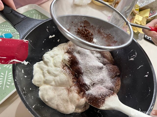 녹은 마시멜로에 코코아파우더와 탈지분유를 체에 걸러 넣고 있다. / 위키푸디