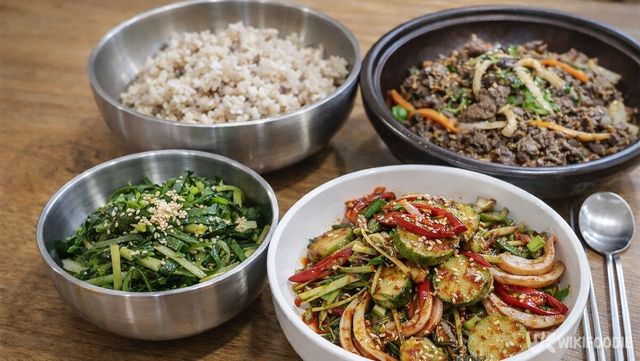 보리밥과 미나리나물, 오이무침, 소불고기가 식탁에 놓여 있다. / 위키푸디