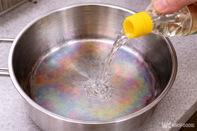 무지개 얼룩이 생긴 스테인리스 냄비에 식초를 붓고 있다. / 위키푸디